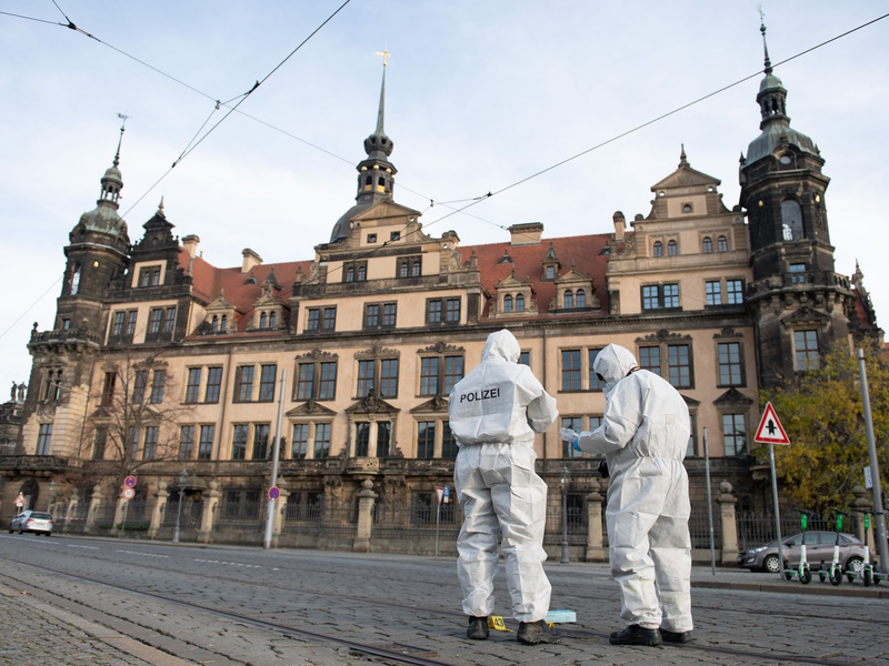 Zwei Mitarbeiter der Spurensicherung stehen vor dem Residenzschloss mit dem Grünen Gewölbe. - Foto: Sebastian Kahnert/dpa