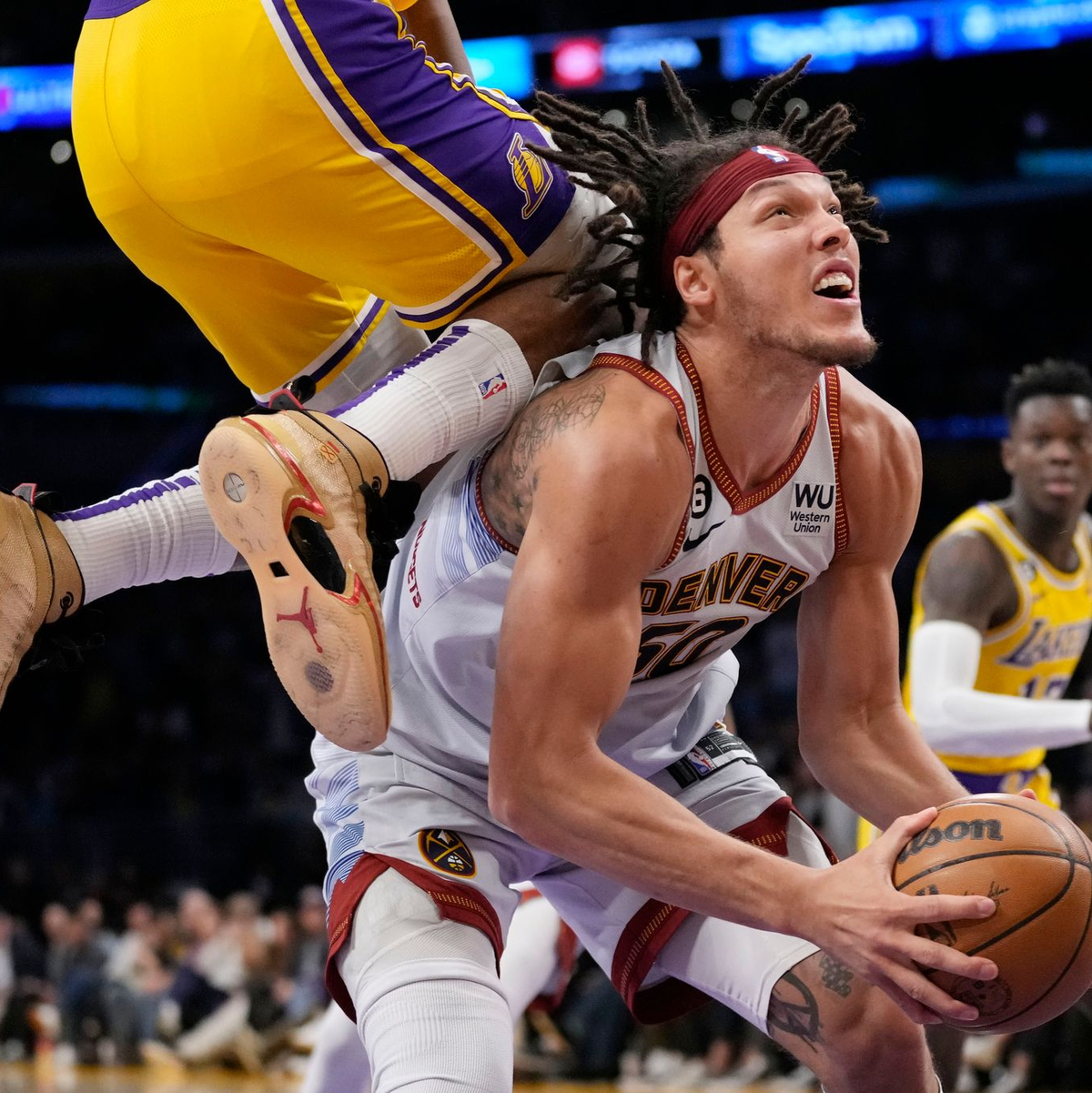 Aaron Gordon von den Denver Nuggest (unten) wird von Lakers-Spieler Rui Hachimura gefoult. - Foto: Ashley Landis/AP
