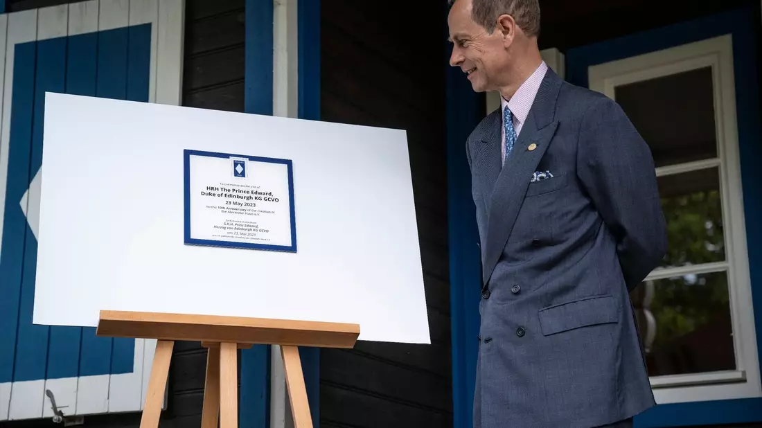 Prinz Edward schaut sich die Ehrenplakette am Alexander Haus in Groß Glienicke an. - Bild: Hannes P Albert/dpa