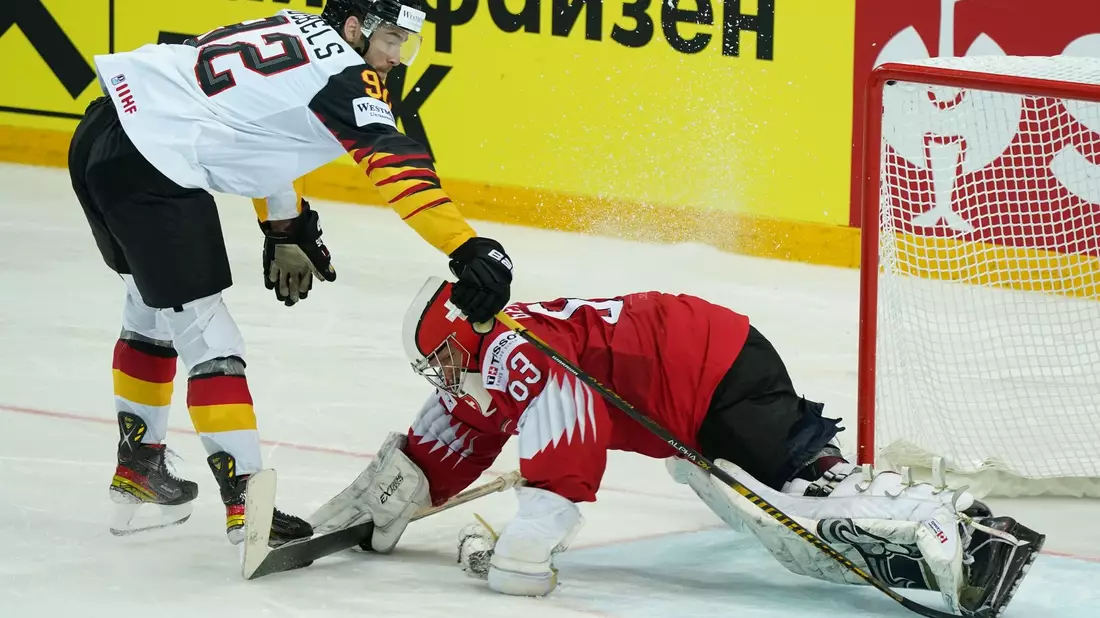 Deutschlands Marcel Noebels schießt den Puck am Schweizer Torwart Leonardo Genoni vorbei. Am Donnerstag kommt es in Riga zum WM-Viertelfinale gegen die Schweiz. - Bild: Roman Koksarov/dpa