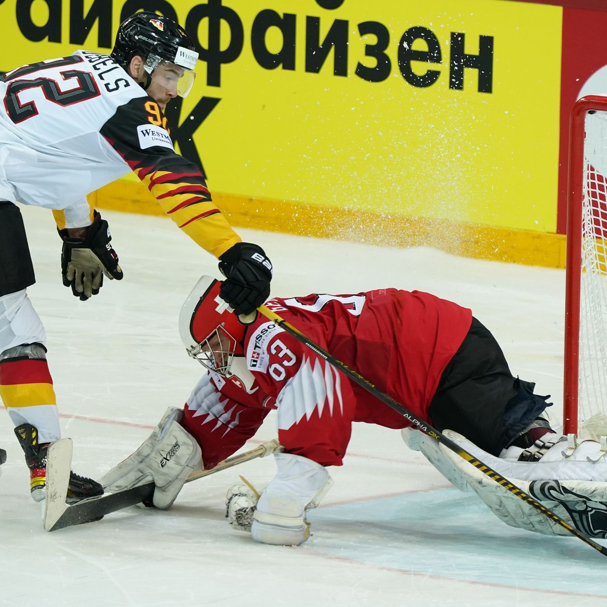 Deutschlands Marcel Noebels schießt den Puck am Schweizer Torwart Leonardo Genoni vorbei. Am Donnerstag kommt es in Riga zum WM-Viertelfinale gegen die Schweiz. - Foto: Roman Koksarov/dpa