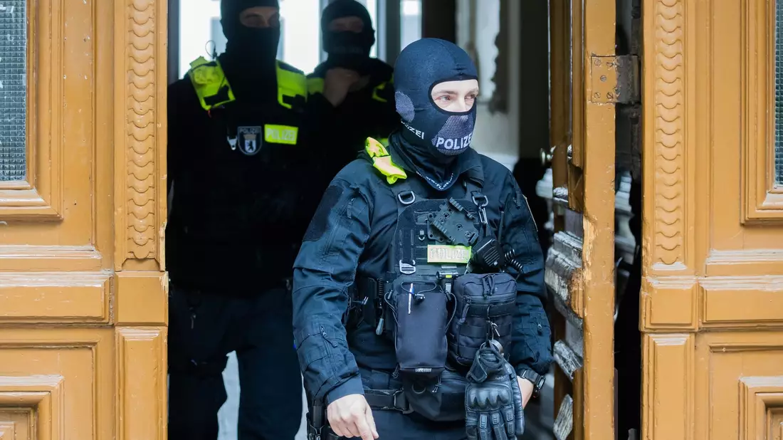 Polizisten nach einer Hausdurchsuchung in Berlin-Kreuzberg - bundesweit waren mehrere Dutzend Beamte im Einsatz. - Bild: Christoph Soeder/dpa