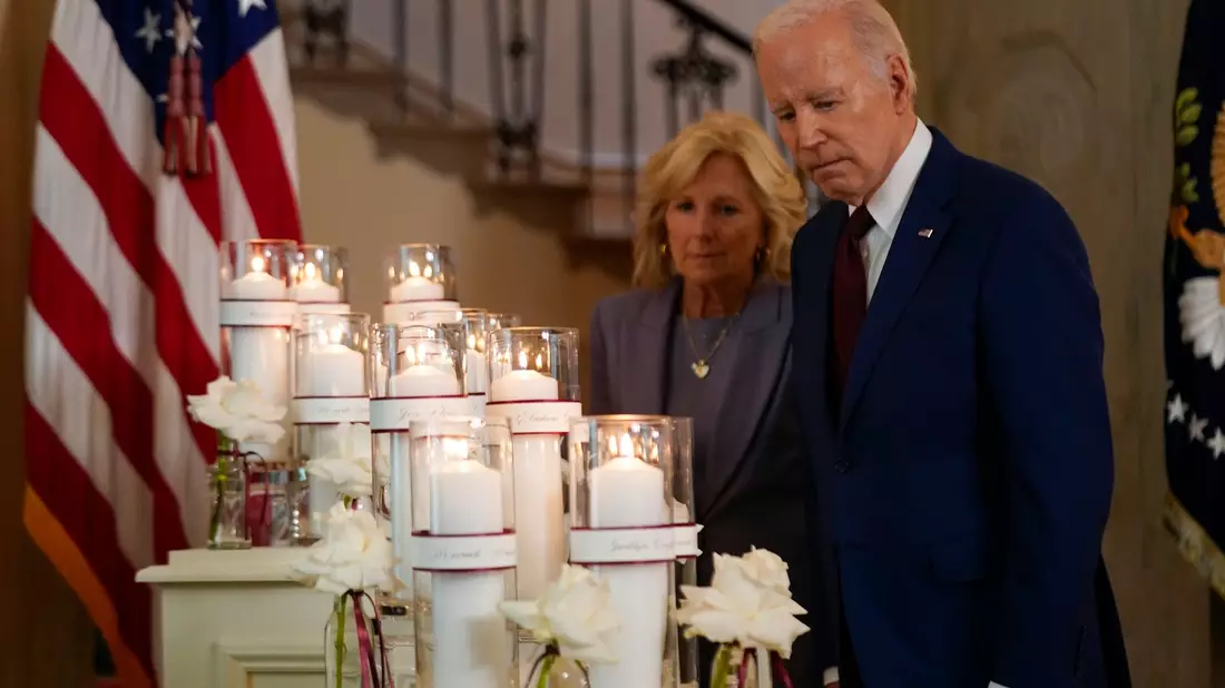 Joe Biden und die First Lady Jill Biden halten vor einer Gedenkanzeige zum einjährigen Jahrestag des Amoklaufs an einer Grundschule inne. - Bild: Andrew Harnik/AP