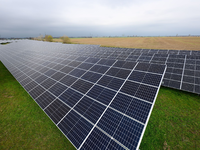 Solaranlagen sind für ein Photovoltaik-Speicher-Kraftwerk auf einer Wiese montiert. - Foto: Robert Michael/dpa