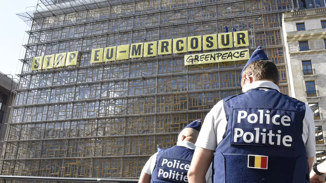 Umweltaktivistinnen und -aktivisten sind aus Protest gegen ein Handelsabkommen mit südamerikanischen Staaten auf das Gebäude des EU-Ministerrats geklettert. Sie brachten dort am Donnerstag Banner mit der Aufschrift «Stop EU Mercosur» an. - Bild: Marek Majewsky/dpa-Zentralbild/dpa