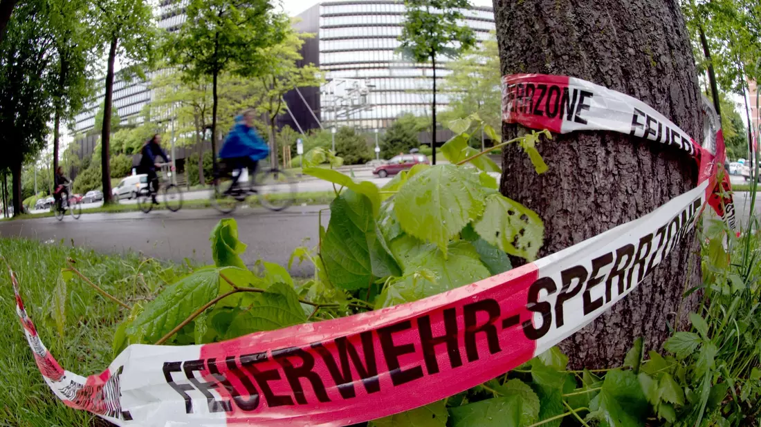 Absperrband der Feuerwehr hängt an einem Baum: Am späten Abend des 28.05.2013 wurde an der Stelle ein 31-Jähriger von einem unbekannten Mann so schwer verletzt, dass er kurze Zeit später im Krankenhaus starb - Bild: picture alliance / dpa