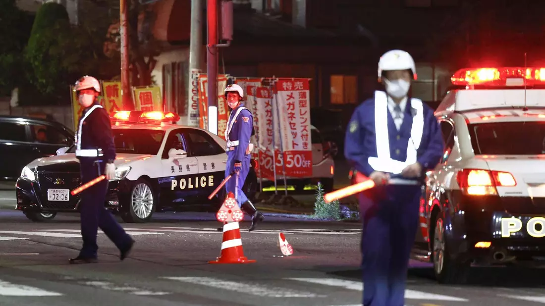 Polizisten in Nakano in der Nähe eines Gebäudes, in dem sich der Täter Mann verschanzt hat. - Bild: Takuto Kaneko/Kyodo News/AP/dpa