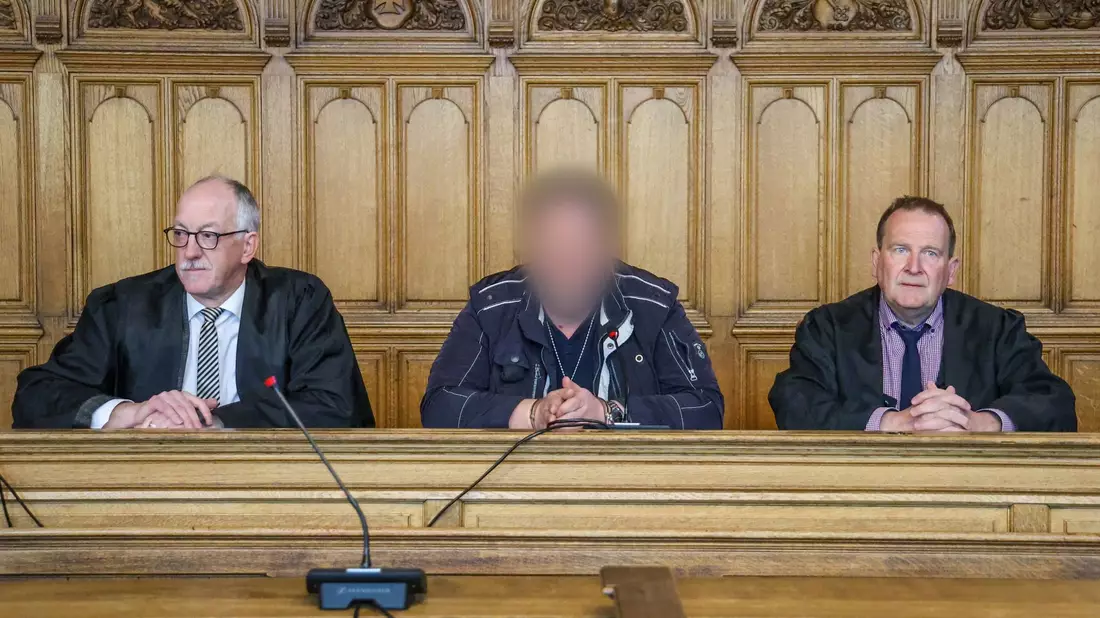 Der Angeklagte (M) sitzt vor der Urteilsverkündung im Prozess wegen Mordes im Landgericht Bremen zwischen seinen Verteidigern. - Bild: Focke Strangmann/dpa