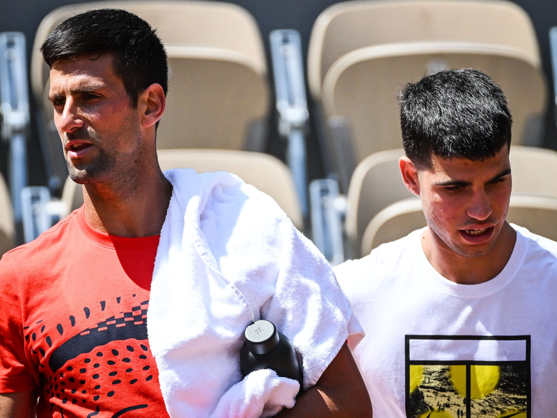Novak Djokovic (l) aus Serbien und Carlos Alcaraz aus Spanien gehen nebeneinander während einer Trainingseinheit für die French Open 2023. - Foto: Matthieu Mirville/ZUMA Press Wire/dpa