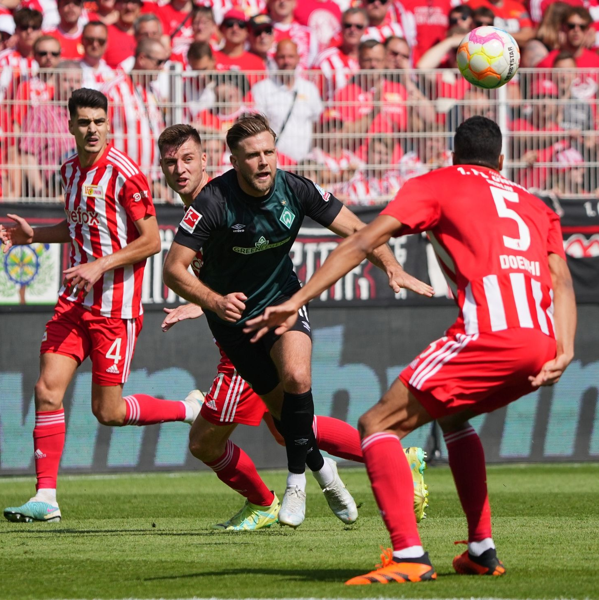 Werder Bremens Niclas Füllkrug (M) versucht sich gegen die Unioner Diogo Leite, Robin Knoche und Danilho Doekhi durchzusetzen. - Foto: Soeren Stache/dpa