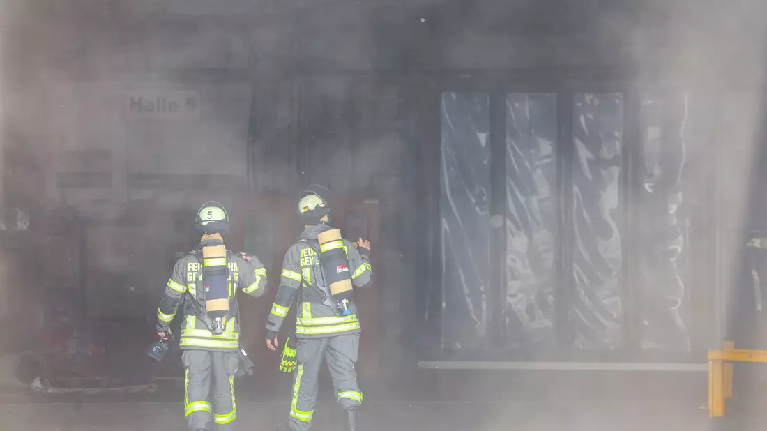Kräfte der Feuerwehr verschaffen sich nach der Explosion in einer Industriehalle einen Überblick. - Bild: Tim Oelbermann/dpa