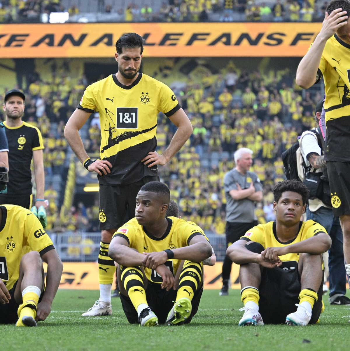 Spieler von Borussia Dortmund sitzen nach dem Spiel enttäuscht auf dem Platz. - Foto: Bernd Thissen/dpa