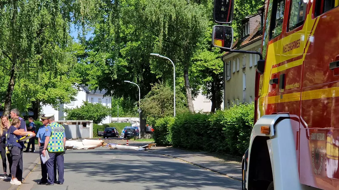 Trümmer liegen auf der Straße nach dem Absturz eines Leichtflugzeugs im Stadtgebiet von Wetzlar. - Bild: Carolin Eckenfels/dpa