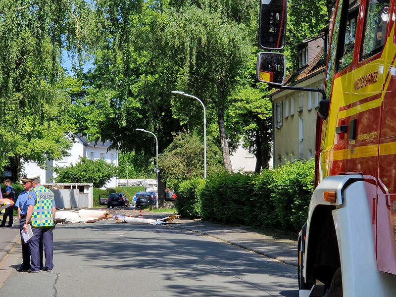 Trümmer liegen auf der Straße nach dem Absturz eines Leichtflugzeugs im Stadtgebiet von Wetzlar. - Foto: Carolin Eckenfels/dpa