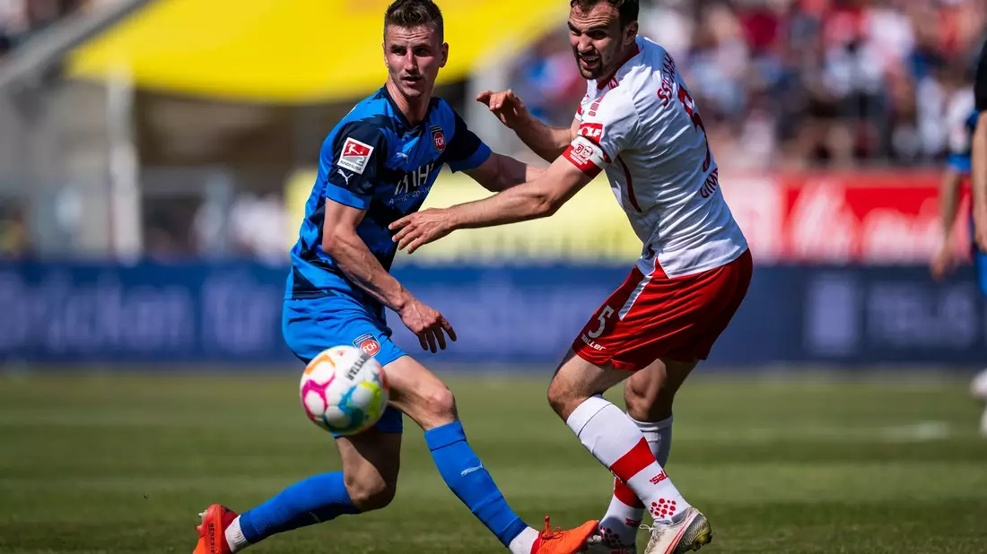 Jan Schöppner von Heidenheim (l) im engen Duell mit Regensburgs Benedikt Gimber. - Bild: Tom Weller/dpa