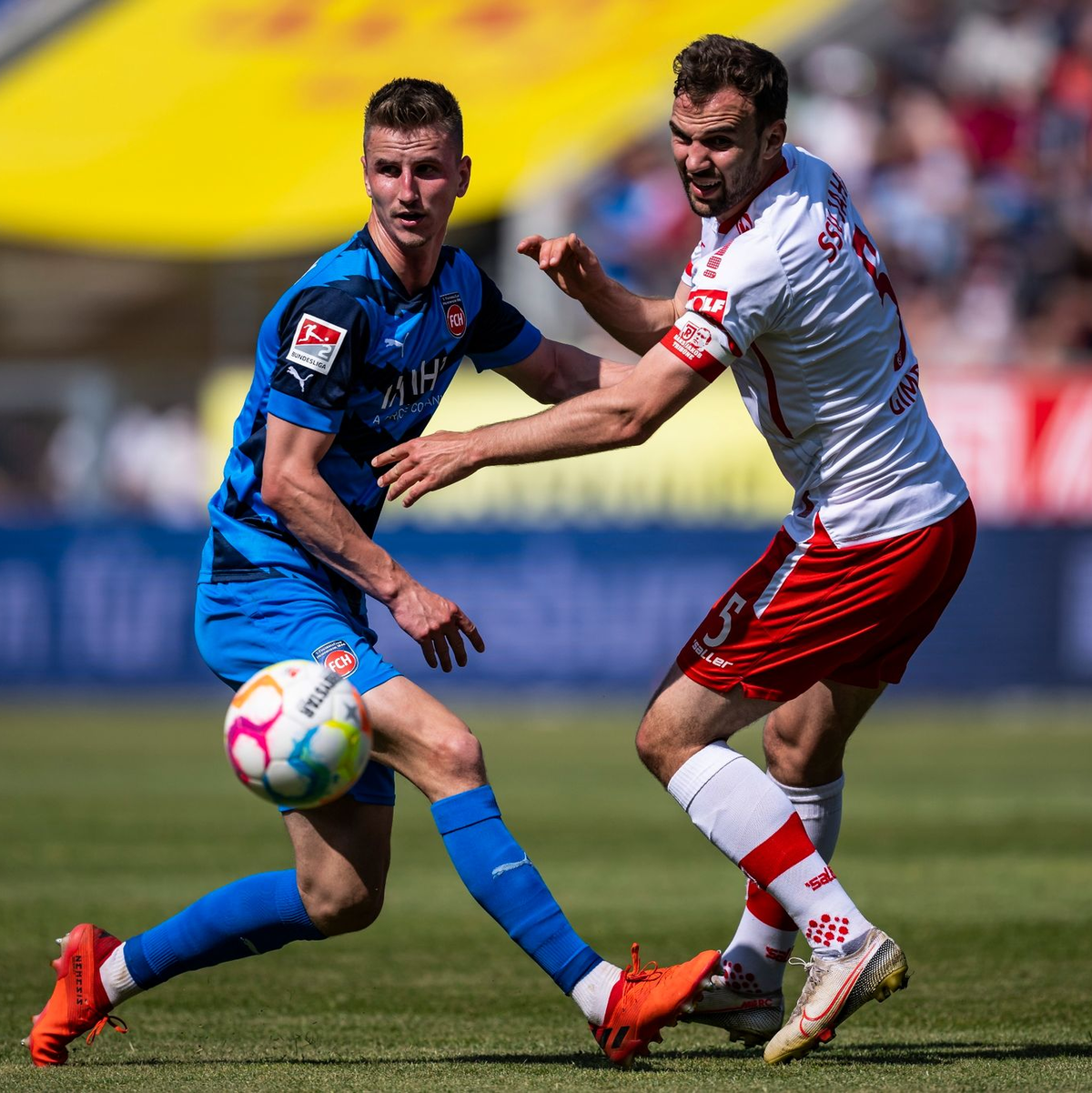 Jan Schöppner von Heidenheim (l) im engen Duell mit Regensburgs Benedikt Gimber. - Foto: Tom Weller/dpa