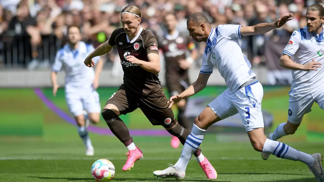 St. Paulis Lukas Daschner (l) und Daniel Gordon vom Karlsruher SC im Zweikampf. - Bild: Michael Schwartz/dpa