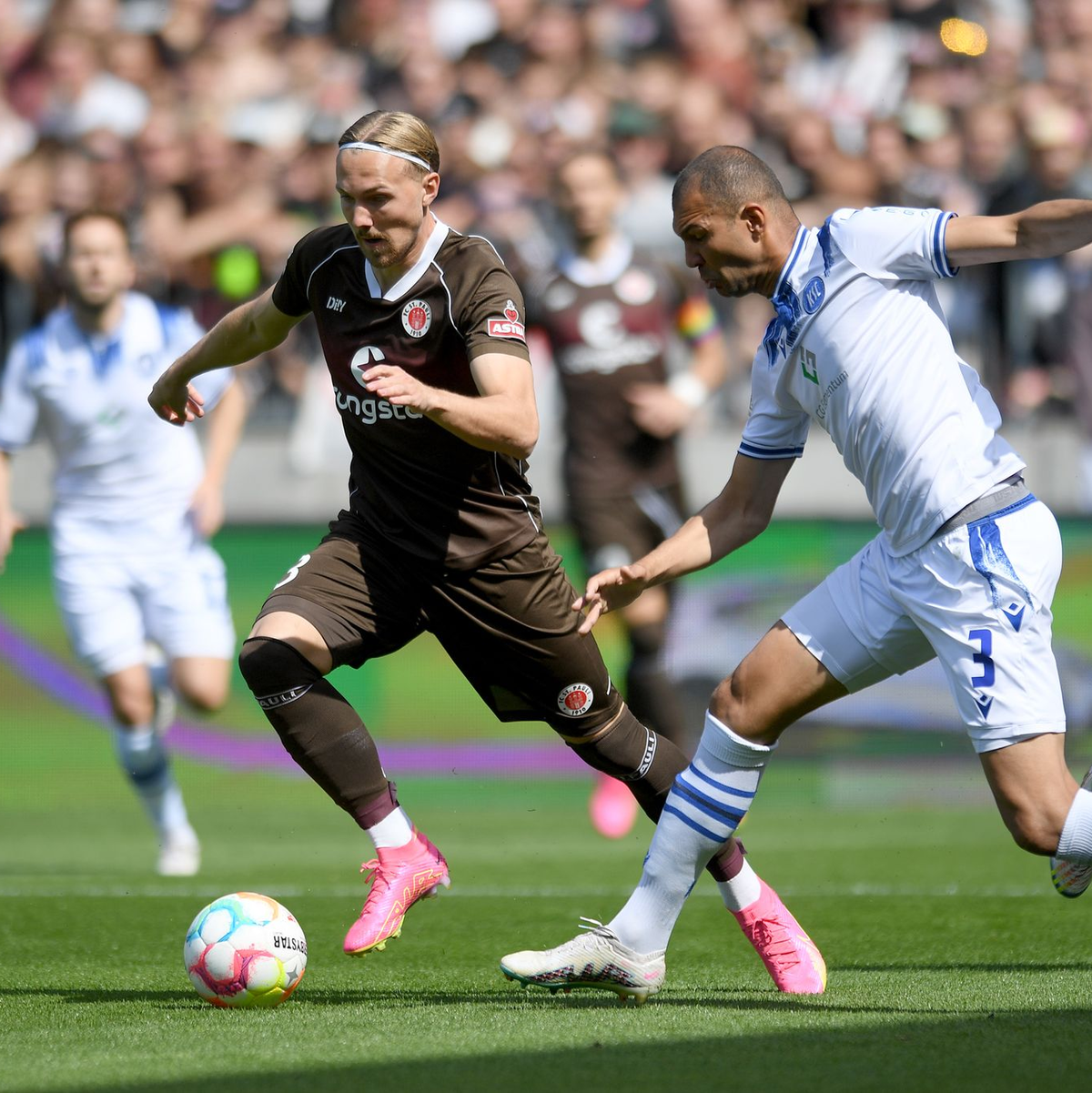 St. Paulis Lukas Daschner (l) und Daniel Gordon vom Karlsruher SC im Zweikampf. - Foto: Michael Schwartz/dpa