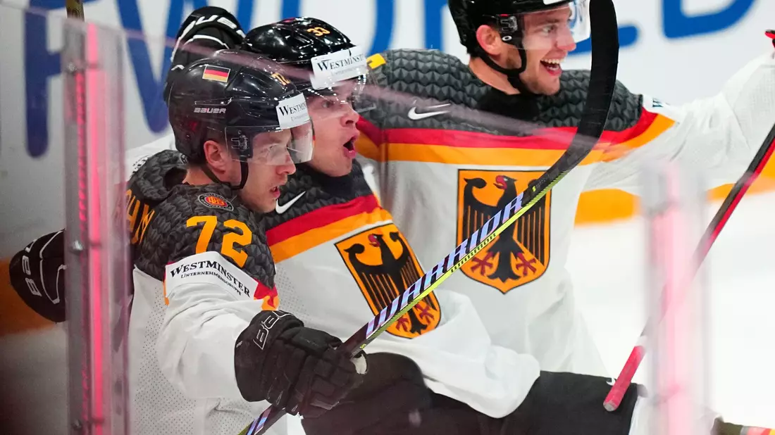 John-Jason Peterka (M) feiert seinen Führungstreffer zum 1:0 mit seinen Teamkollegen. - Bild: Pavel Golovkin/AP/dpa