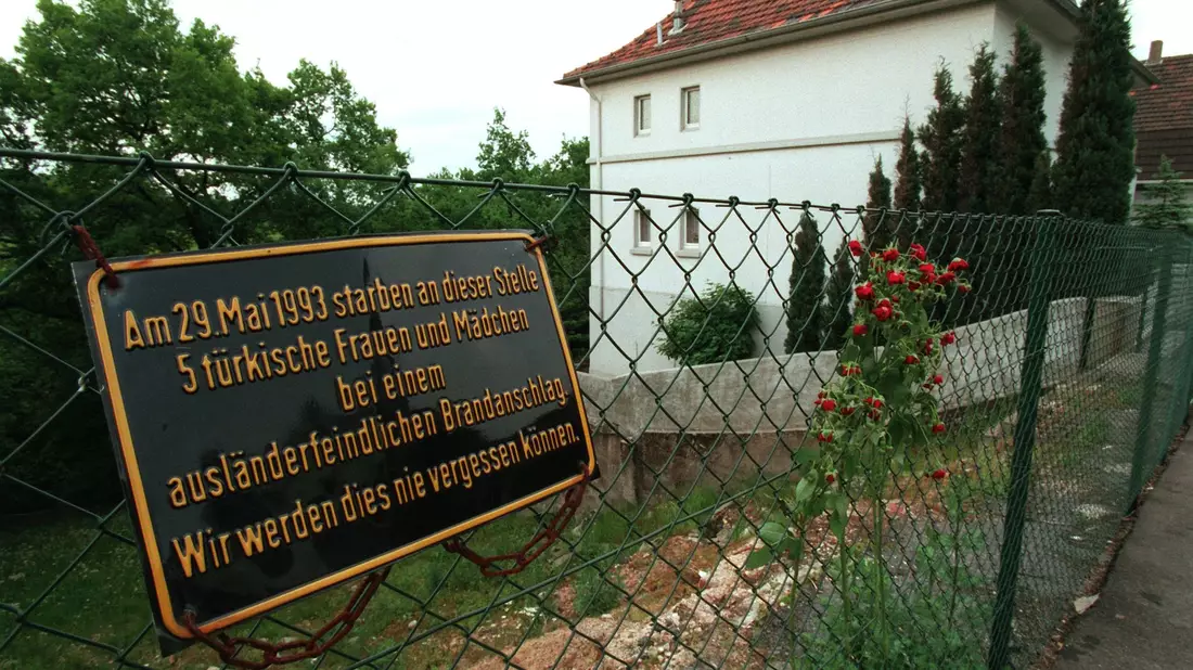 An der Stelle, wo das Haus der türkischen Familie Genc stand, erinnert heute eine Gedenktafel an die Opfer des Brandanschlags. - Bild: Martin Gerten/dpa