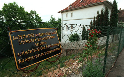 An der Stelle, wo das Haus der türkischen Familie Genc stand, erinnert heute eine Gedenktafel an die Opfer des Brandanschlags. - Foto: Martin Gerten/dpa