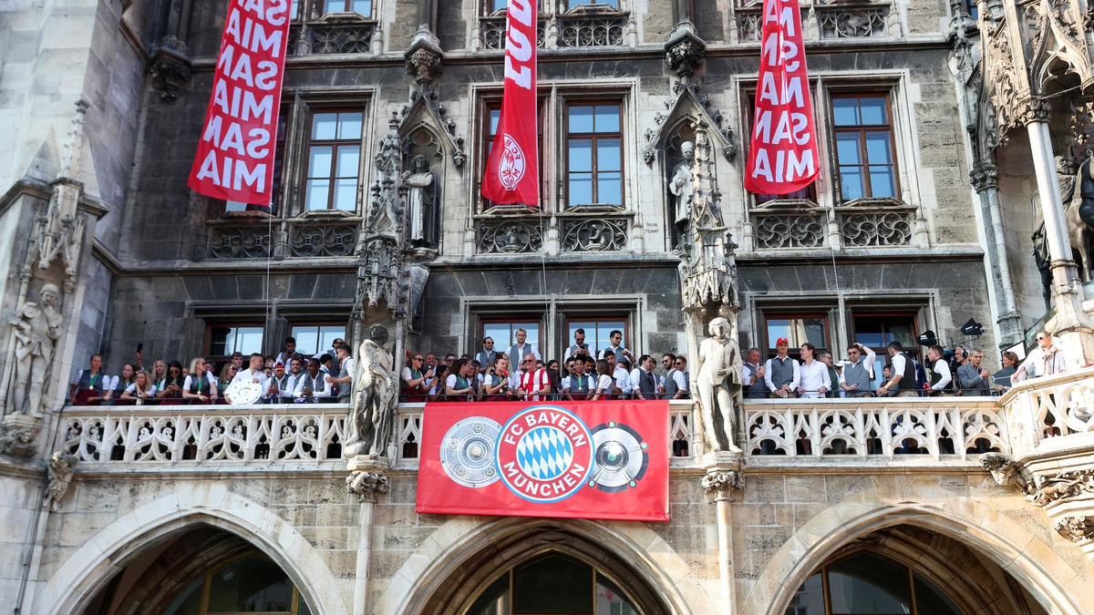 Die Spielerinnen und Spieler des FC Bayern feiern gemeinsam auf dem Rathaus-Balkon. - Foto: Karl-Josef Hildenbrand/dpa