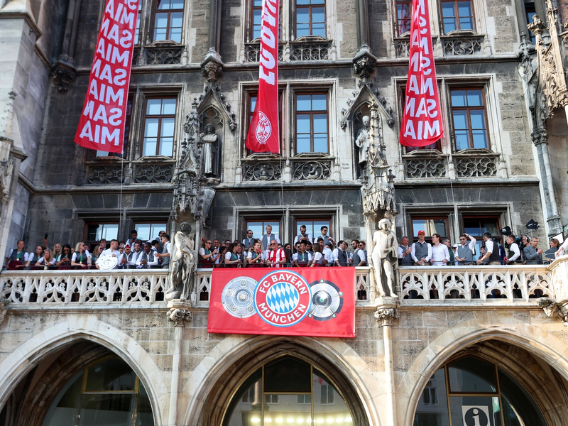 Die Spielerinnen und Spieler des FC Bayern feiern gemeinsam auf dem Rathaus-Balkon. - Foto: Karl-Josef Hildenbrand/dpa