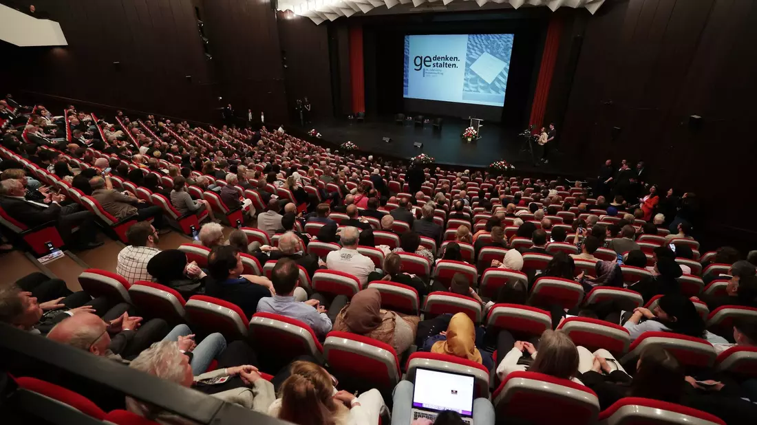 Gäste warten im Theater und Konzerthaus auf den Beginn der zentralen Gedenkfeier zum 30. Jahrestag des Solinger Brandanschlags. - Bild: David Young/dpa