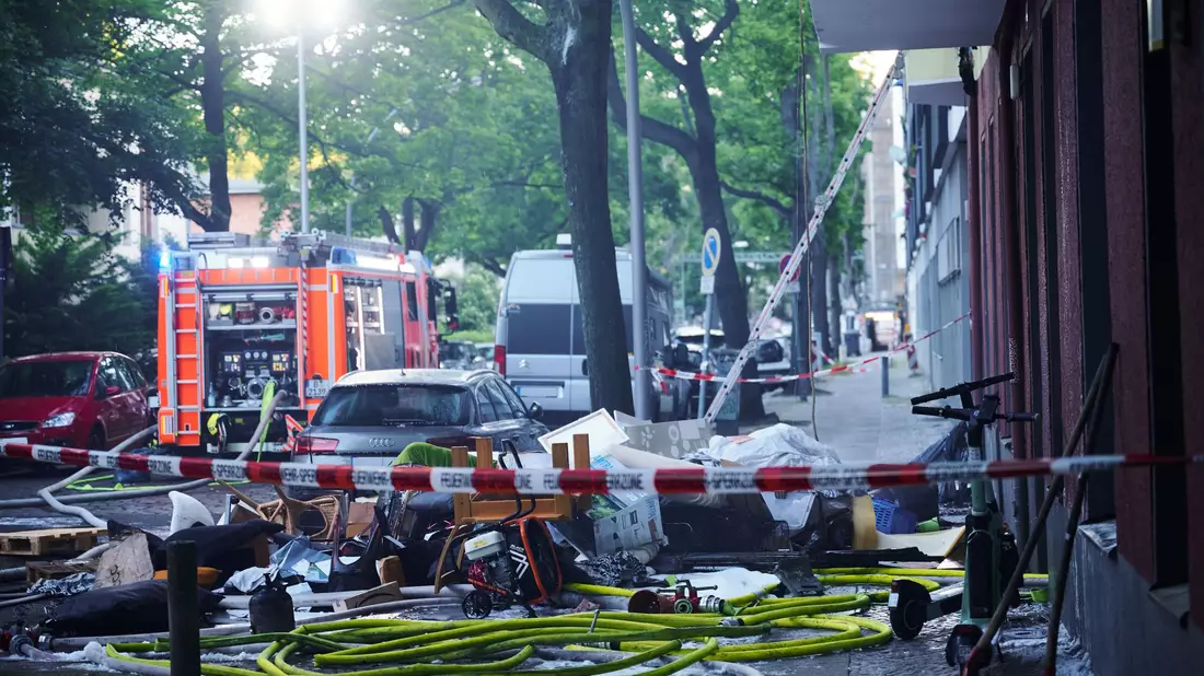 Feuerwehrleute arbeiten mit Atemschutz in der  ausgebrannten Wohnung in Berlin-Wilmersdorf. - Bild: Annette Riedl/dpa