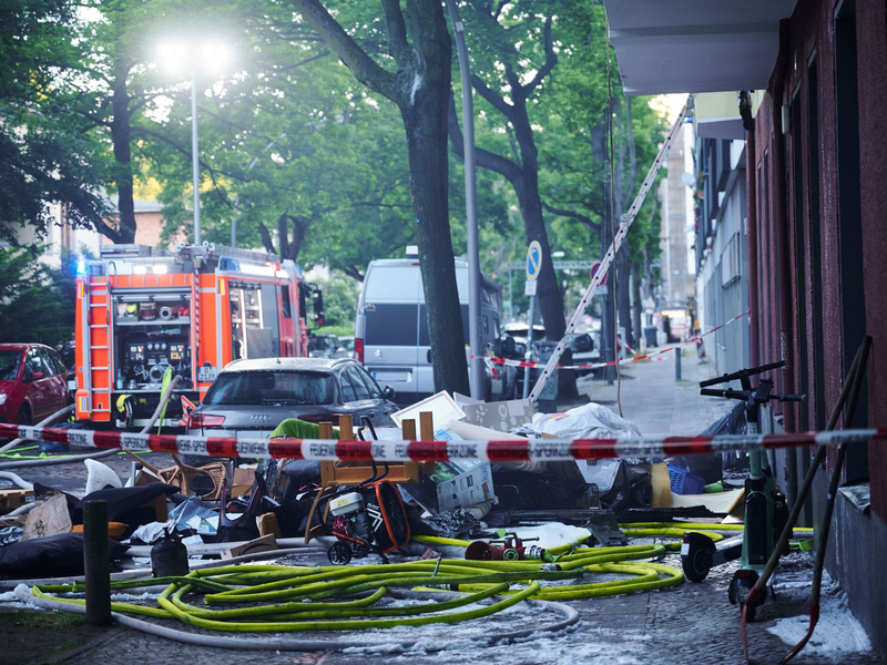 Feuerwehrleute arbeiten mit Atemschutz in der  ausgebrannten Wohnung in Berlin-Wilmersdorf. - Foto: Annette Riedl/dpa