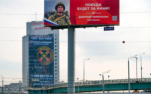 Ein Werbeschild, auf dem für das Militärunternehmen Wagner (hinten) geworben wird und auf dem zu lesen ist «Schließen Sie sich dem Team der Sieger an». - Foto: Alexander Zemlianichenko/AP/dpa