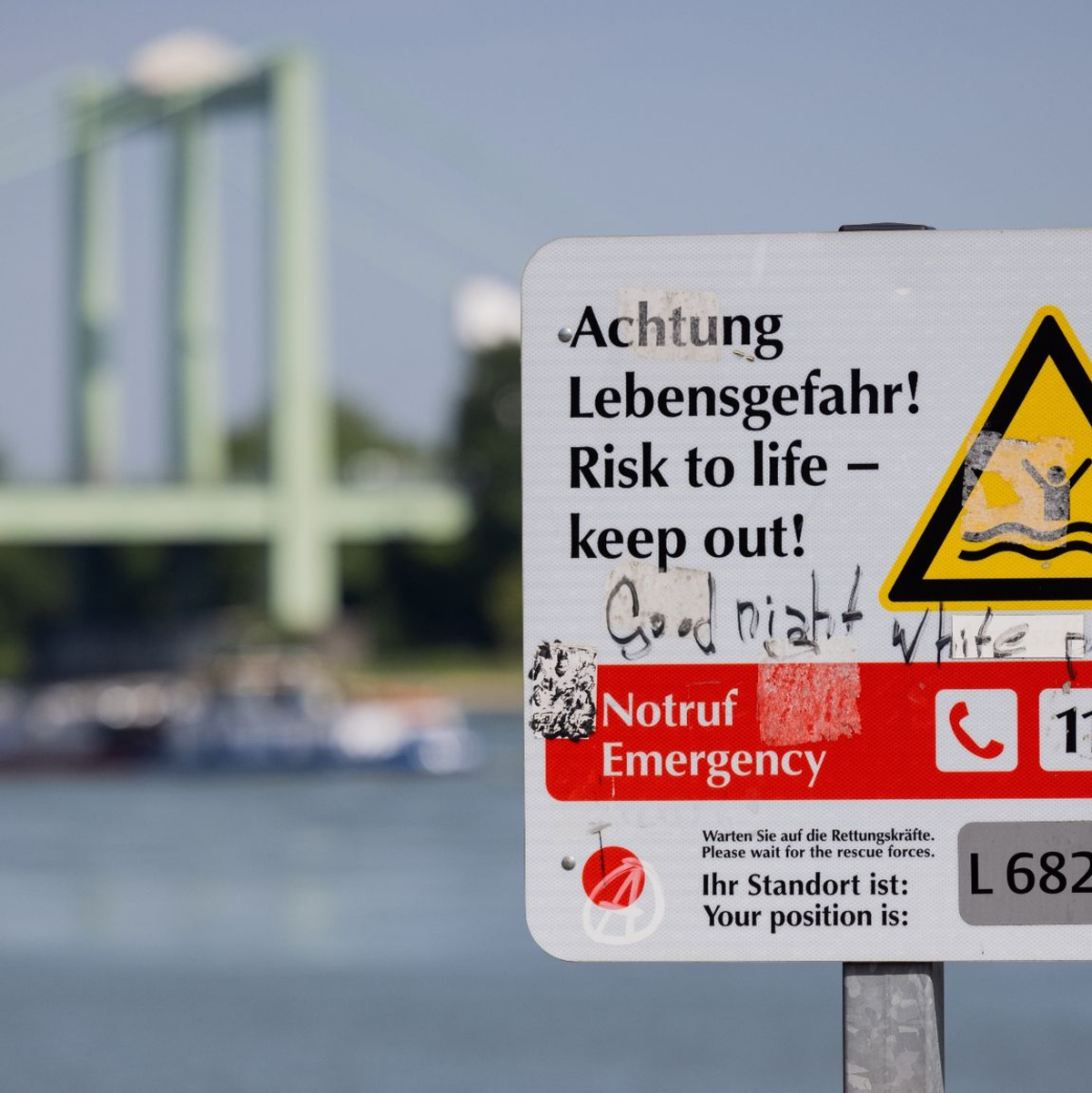 Ein Schild am Rheinufer weist auf die Gefahren beim Schwimmen im Fluss hin. - Foto: Rolf Vennenbernd/dpa