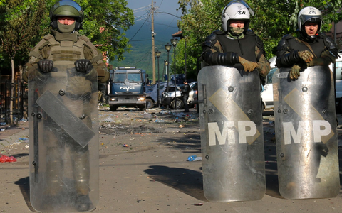 Soldaten und Polizisten bewachen nach den Zusammenstößen zwischen ethnischen Serben und Truppen der Nato-geführten KFOR-Friedenstruppe ein Gebäude in Zvecan. - Foto: Dejan Simicevic/AP