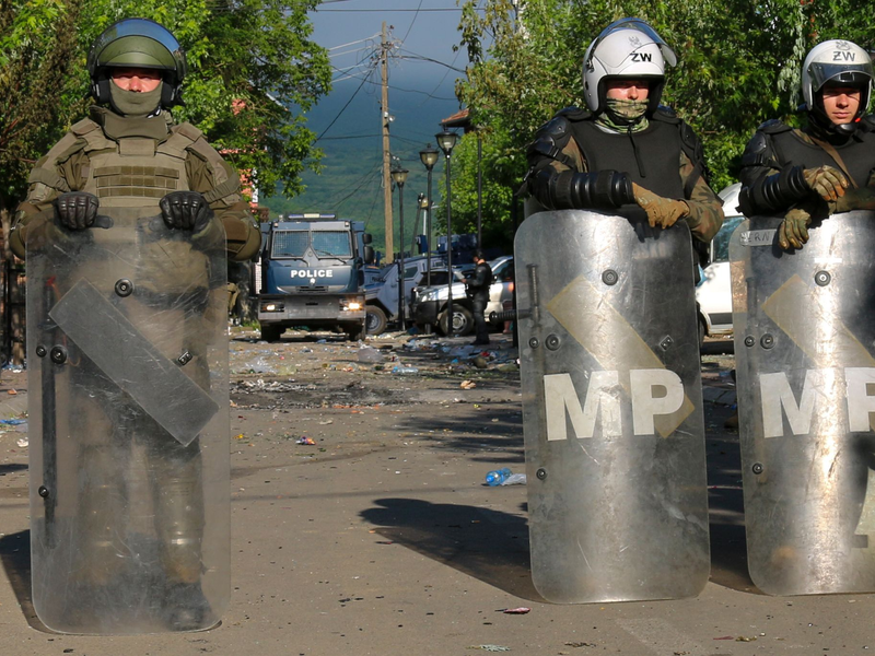 Soldaten und Polizisten bewachen nach den Zusammenstößen zwischen ethnischen Serben und Truppen der Nato-geführten KFOR-Friedenstruppe ein Gebäude in Zvecan. - Foto: Dejan Simicevic/AP