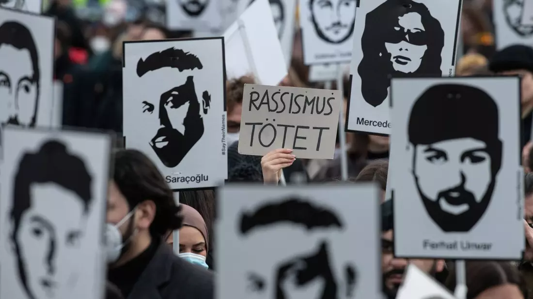 Mit Plakaten und Bildern der Ermordeten erinnern Teilnehmer einer Gedenkveranstaltung an die Opfer des rassistischen Anschlags von Hanau am 19. Februar 2020. - Bild: Boris Roessler/dpa/Archiv