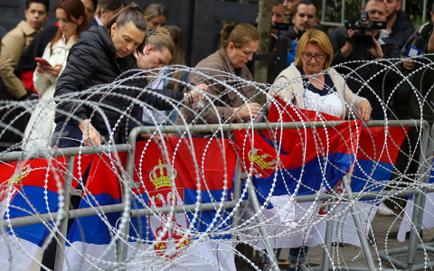 Frauen befestigen serbische Flaggen an einem Zaun vor dem Rathaus während einer Demonstration in der Stadt Zvecan im Norden des Kosovo. - Foto: Bojan Slavkovic/AP