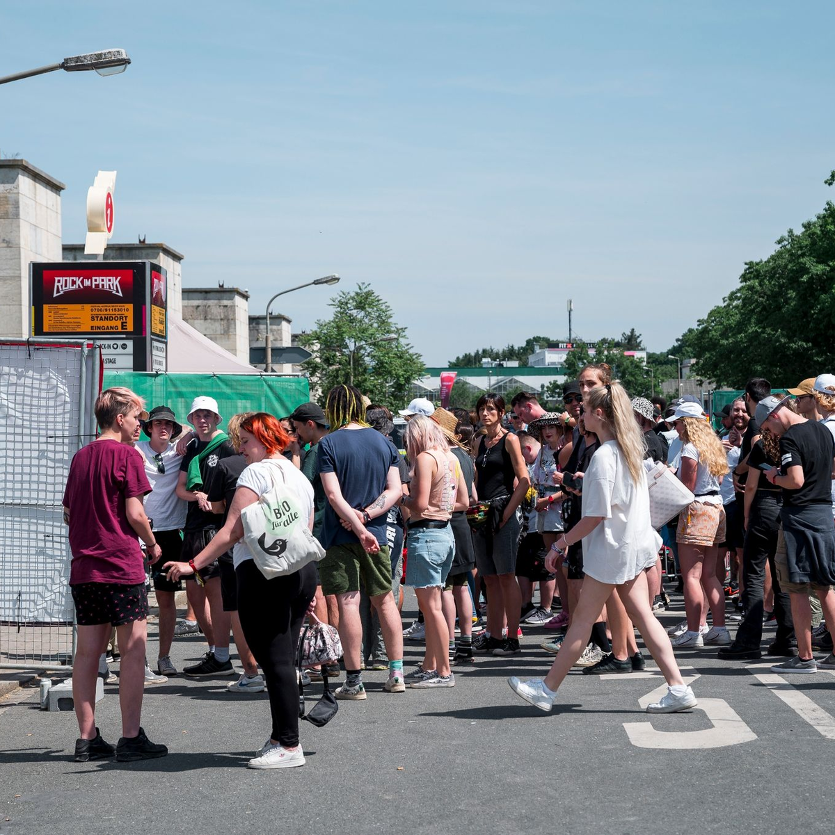 Besucherinnen und Besucher warten vor Beginn des Open-Air-Festivals Rock im Park auf den Einlass. - Foto: Daniel Vogl/dpa