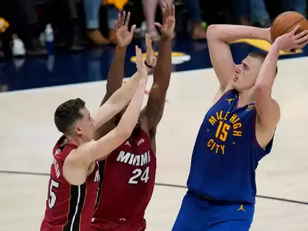 Denvers Nikola Jokic (r) wirft über Miamis Duncan Robinson (l) und Haywood Highsmith. - Foto: David Zalubowski/AP/dpa