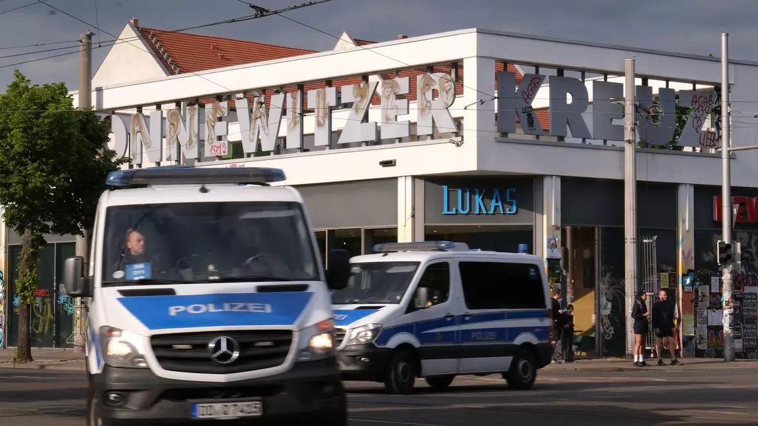 Polizeifahrzeuge passieren das Connewitzer Kreuz. - Bild: Sebastian Willnow/dpa