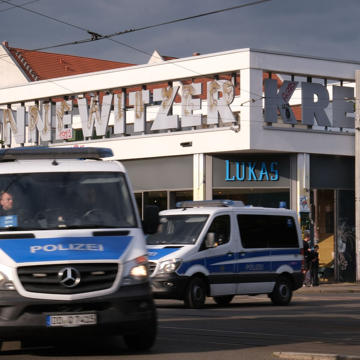 Polizeifahrzeuge passieren das Connewitzer Kreuz. - Foto: Sebastian Willnow/dpa