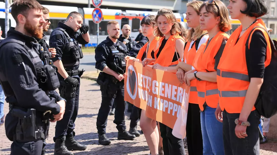 Teilnehmer eines Protestmarsches der Letzten Generation gehen um den Leipziger Ring. - Bild: Jan Woitas/dpa