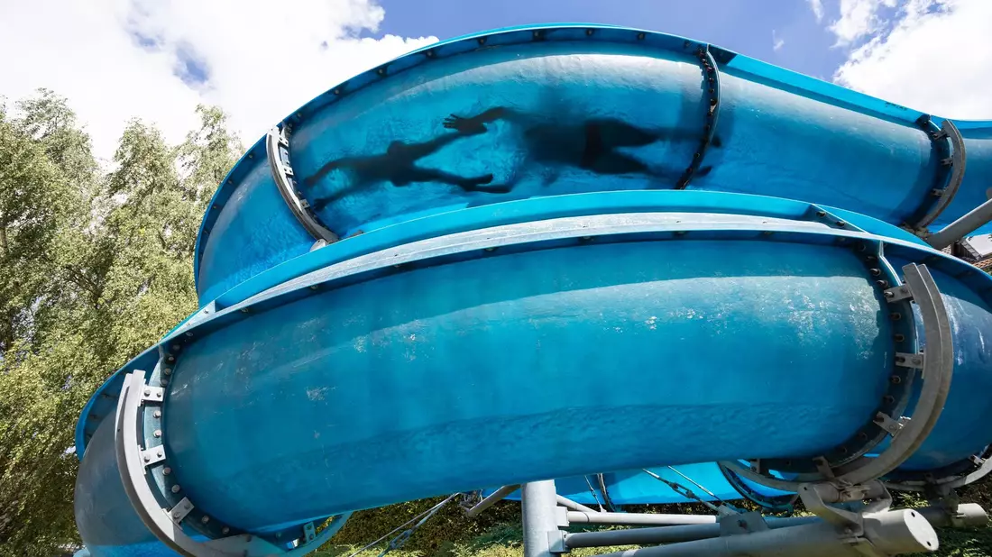 Besucher des FreiBadSoden rutschen in der Wasserrutsche in Bad Soden am Taunus. - Bild: Hannes P. Albert/dpa