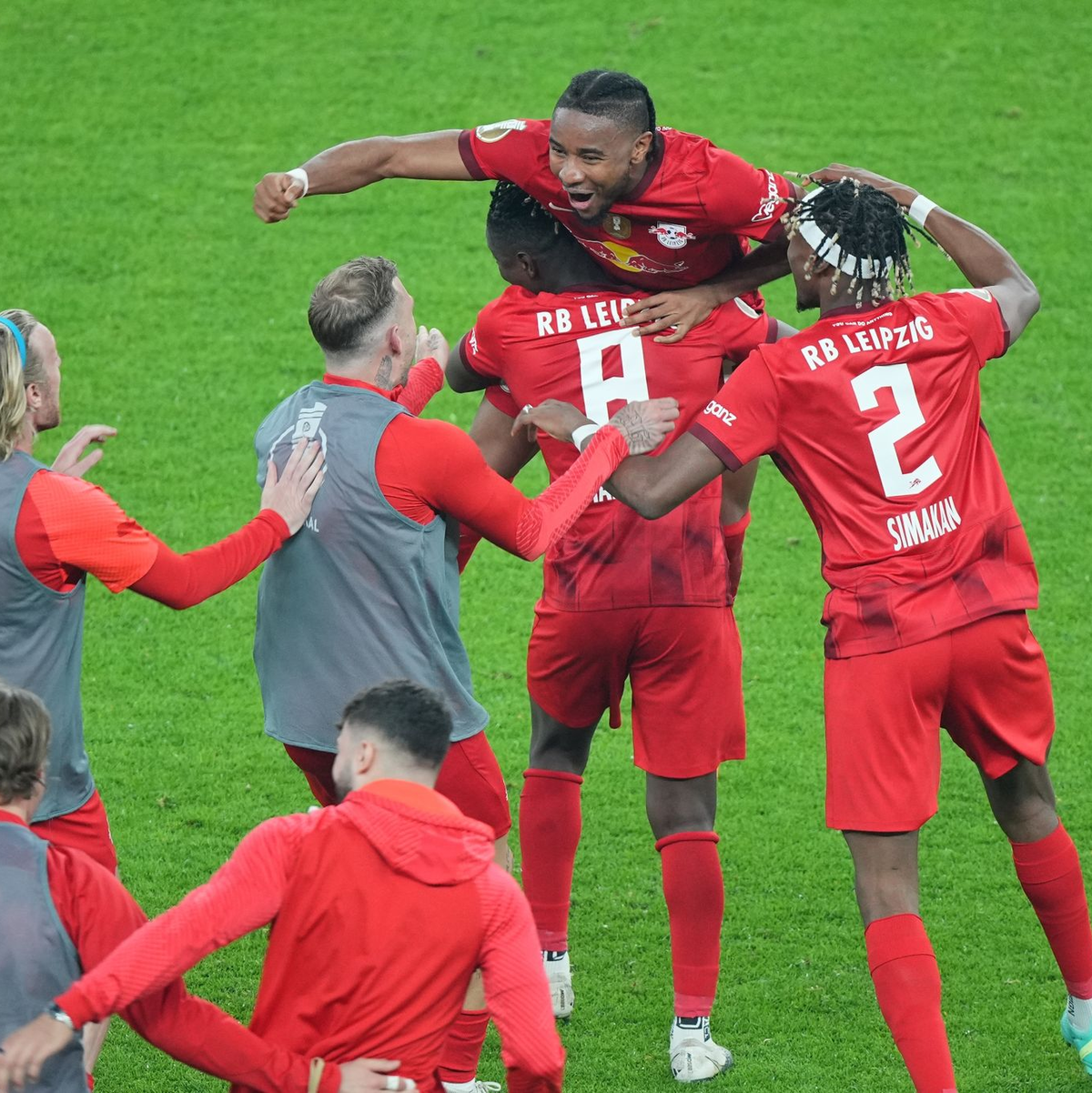 Leipziger Spieler stürmen nach dem Abpfiff auf Matchwinner Christopher Nkunku (M, oben) zu. - Foto: Sören Stache/dpa