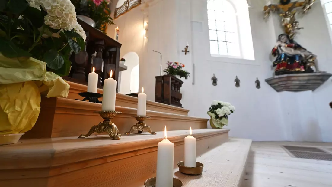 In der Wallfahrtskirche St. Anton in Garmisch-Partenkirchen stehen fünf Kerzen zum Gedenken an die Todesopfer. - Bild: Angelika Warmuth/dpa