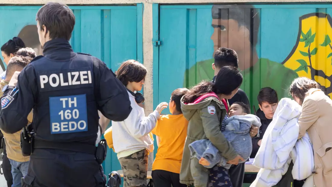 Geflüchtete werden nach dem Brand betreut. - Bild: Michael Reichel/dpa
