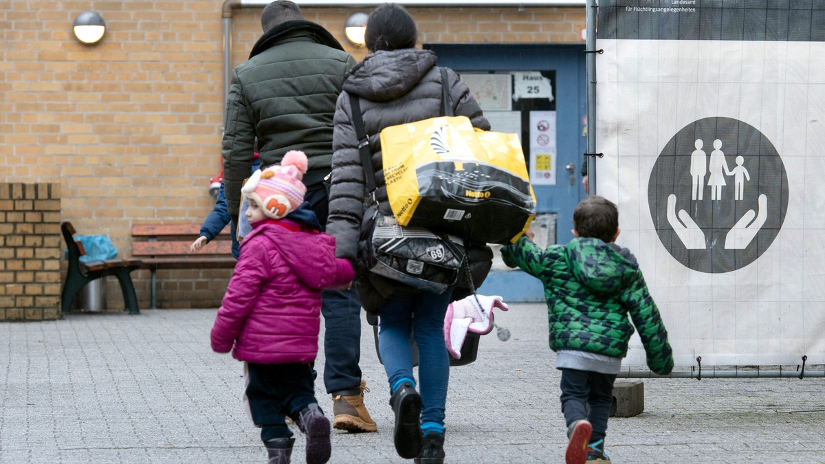 Aus ihrer Heimat geflohene Menschen betreten das Gelände einer Erstaufnahmeeinrichtung in Berlin. - Foto: Paul Zinken/dpa