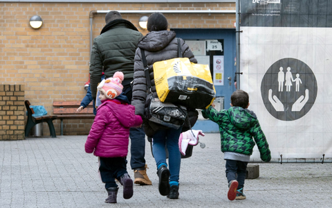 Aus ihrer Heimat geflohene Menschen betreten das Gelände einer Erstaufnahmeeinrichtung in Berlin. - Foto: Paul Zinken/dpa