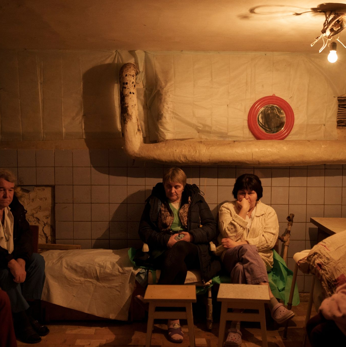 Krankenhauspersonal sitzt während eines Luftangriffsalarms nordöstlich von Kiew in einem Keller, der als Luftschutzbunker genutzt wird. - Foto: Felipe Dana/AP/dpa