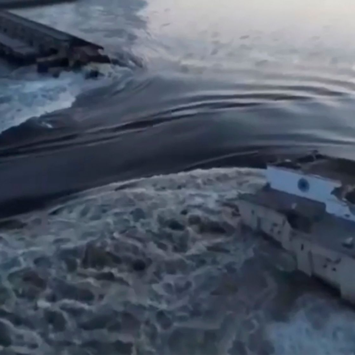 Das vom ukrainischen Präsidialamt über AP veröffentlichte Videostandbild zeigt Wasser, das durch einen Durchbruch im Kachowka-Staudamm fließt. - Foto: Uncredited/Ukrainian Presidential Office/AP/dpa