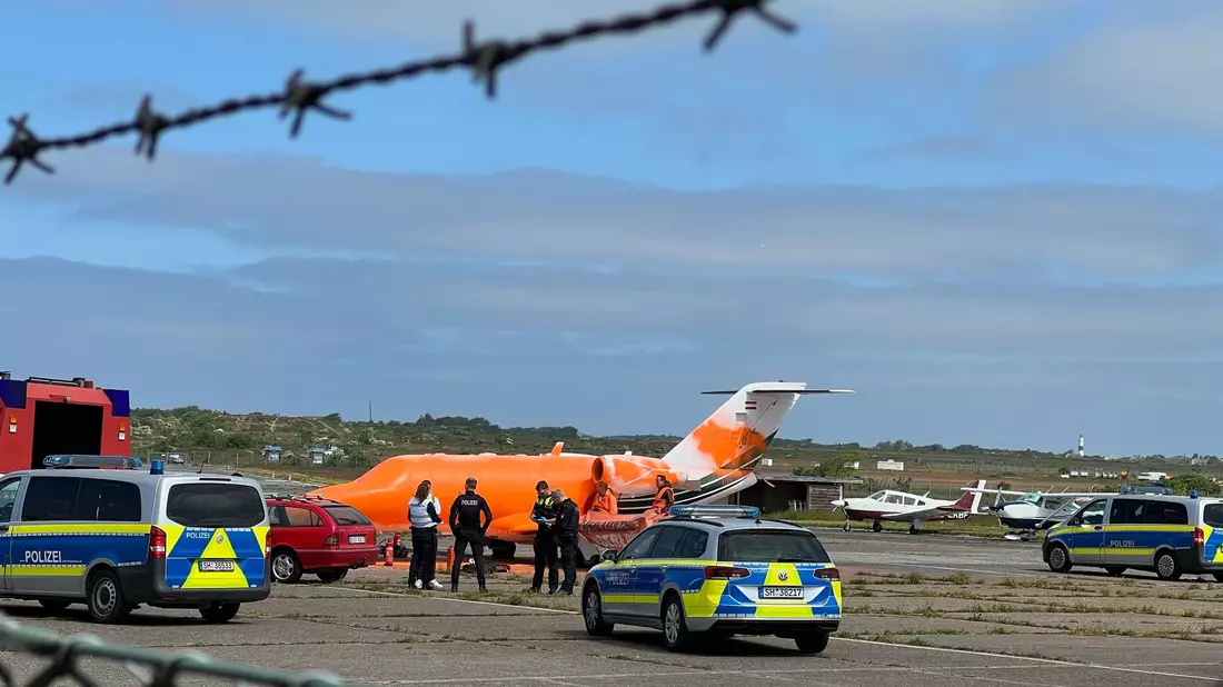 Mit oranger Farbe besprühten Demonstranten auf Sylt einen Privatjet. - Bild: Julius Schreiner/TNN/dpa